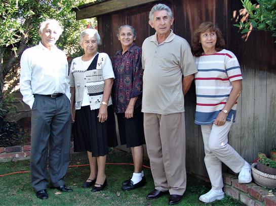 Five friends gather in a backyard, enjoying each other's company and conversation.