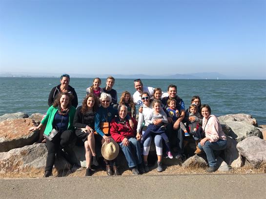 Friends gather by the ocean on a sunny day, sharing smiles and creating lasting memories together.