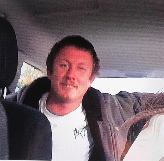 Two friends pose happily inside a car during a road trip, enjoying each other's company.