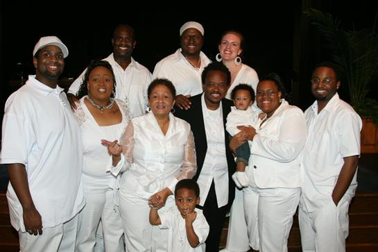 A joyful family gathers, dressed in white, celebrating close relationships under the night sky.