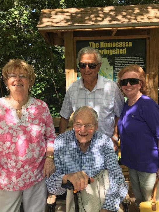 Four seniors smile while visiting the Homosassa Springs Wildlife State Park in Florida.