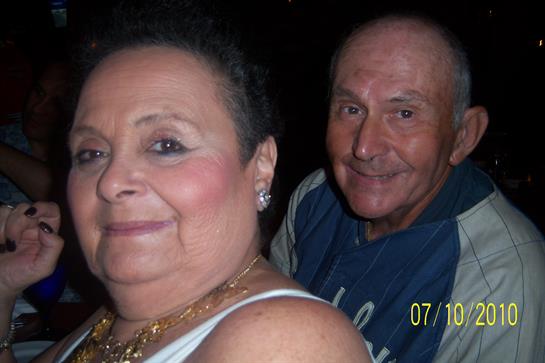 Two seniors share a happy moment at a social gathering, radiating warmth and joy.