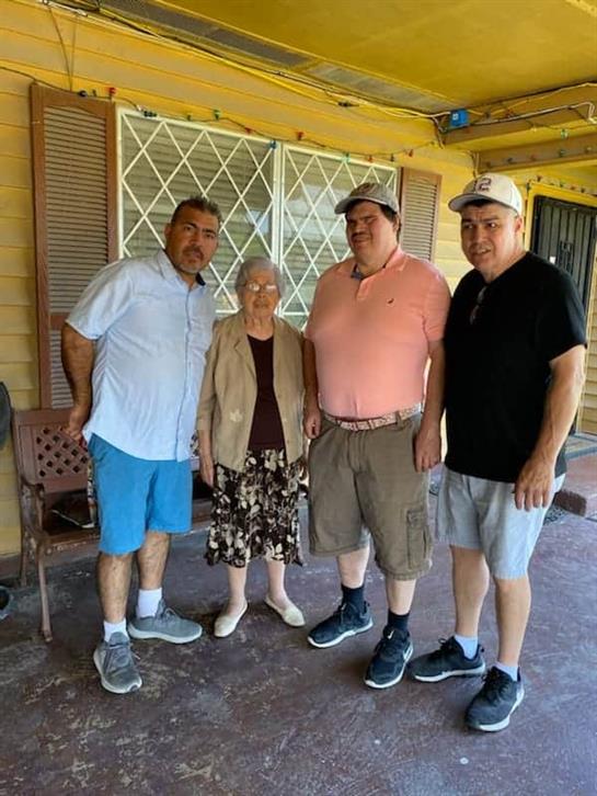 Four family members smile together on a porch, making memories at their reunion.