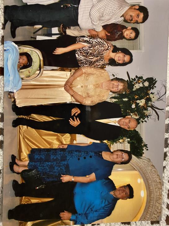 Group in formal wear celebrates a special occasion amid festive decorations.