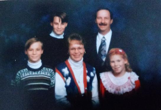 A family poses indoors, exuding cheer in playful late 1980s clothing.
