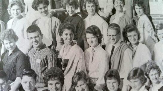 Students are gathered together, smiling and engaged during a school event in a classroom.