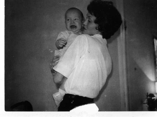 A mother tenderly embraces her crying baby in a warm, comforting atmosphere during the evening.
