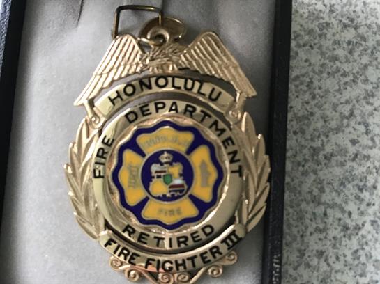 A retired firefighter's badge from Hawaii showcases dedication and service to the community.