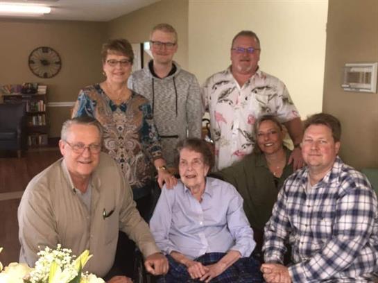 Family members share joy and laughter while celebrating a special birthday in a warm setting.