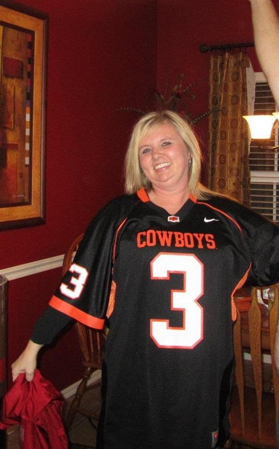 Friends gather in a cozy home, wearing jerseys, celebrating with laughter during a sports event.
