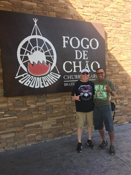 Friends enjoy a moment outside a Brazilian steakhouse, smiling and posing for a fun photo together.