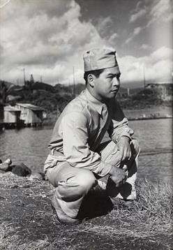 A soldier kneels by the water, embodying determination and resilience in a historic moment.