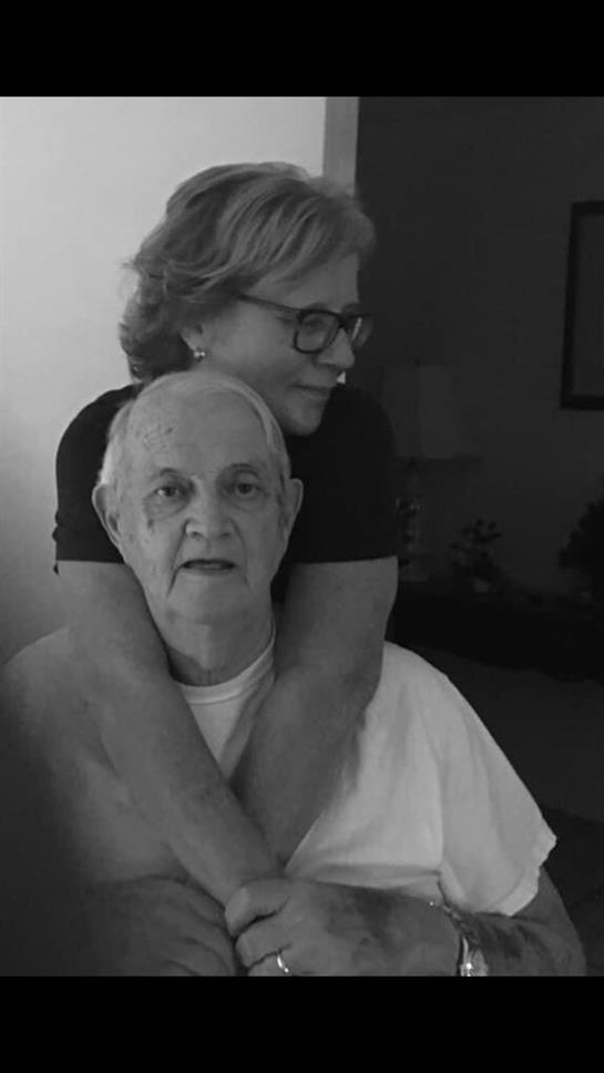 A caregiver shares a warm moment with an elderly man, showcasing love and connection in a cozy home.