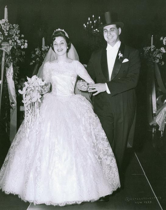 Bride and groom joyfully walk together during their wedding, surrounded by floral decorations.