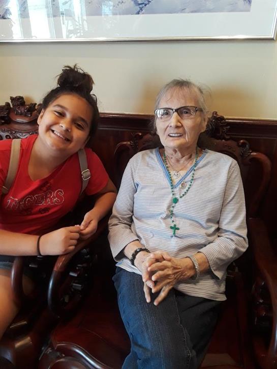A girl and elderly woman share a cozy moment in a warm, inviting room.