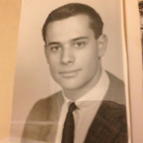 Black and white portrait captures a young man in formal wear with a confident smile.