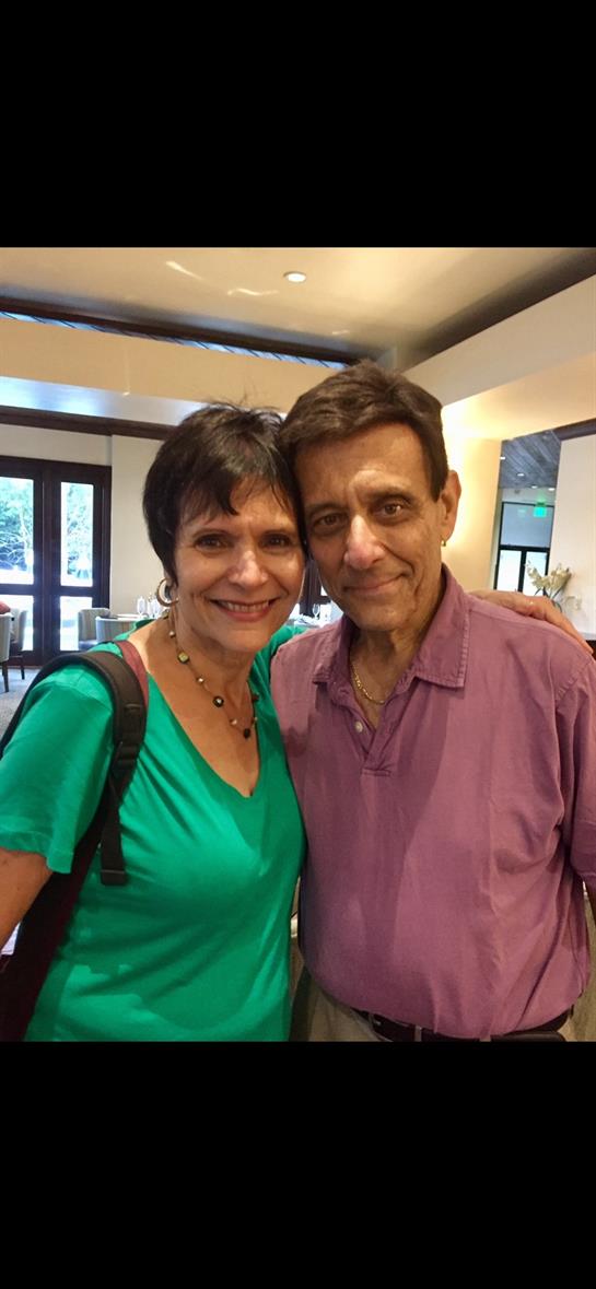 Two individuals share a joyful moment in a cozy dining area filled with natural light.