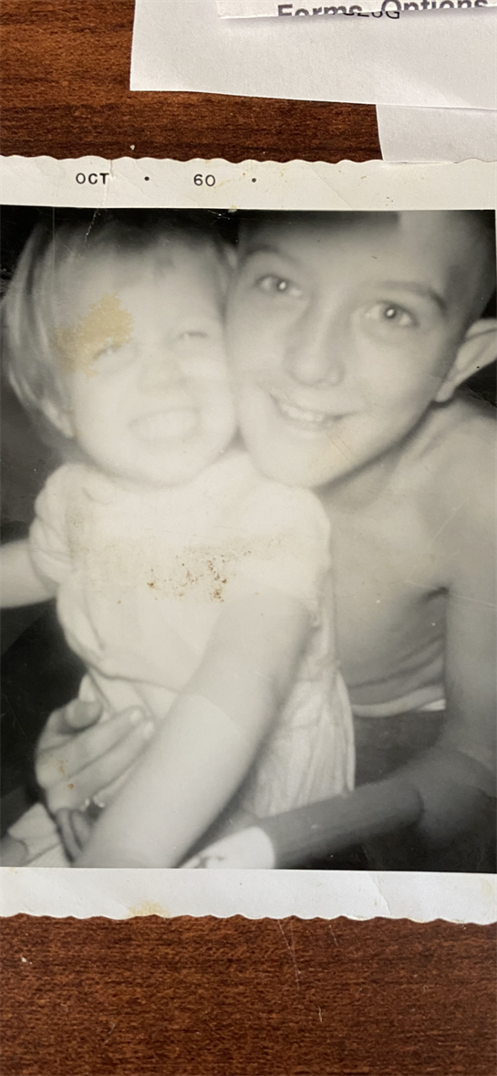 Two young siblings embrace and smile brightly, capturing a moment of happiness and connection.