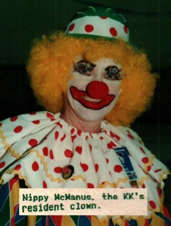 A cheerful clown entertains guests at a lively event, showcasing bright colors and joyful demeanor.