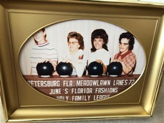 Four bowlers proudly display their trophies at a community event in St. Petersburg, Florida.