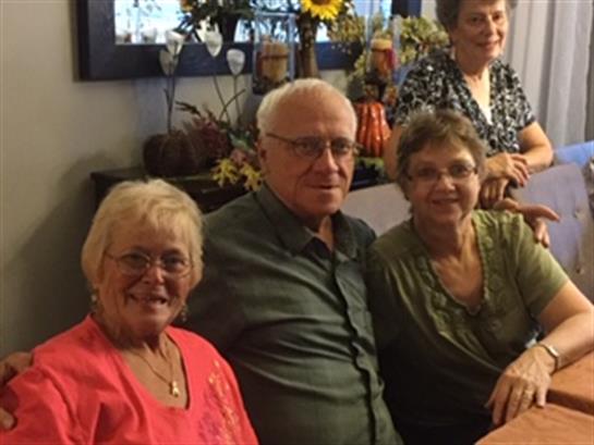 Group of friends gather in a cozy indoor space, sharing laughter and enjoying each other's company.