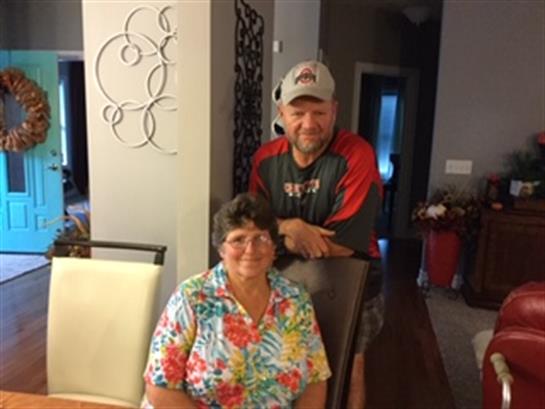 Two relatives smile together in a warm and inviting dining area, enjoying family time.