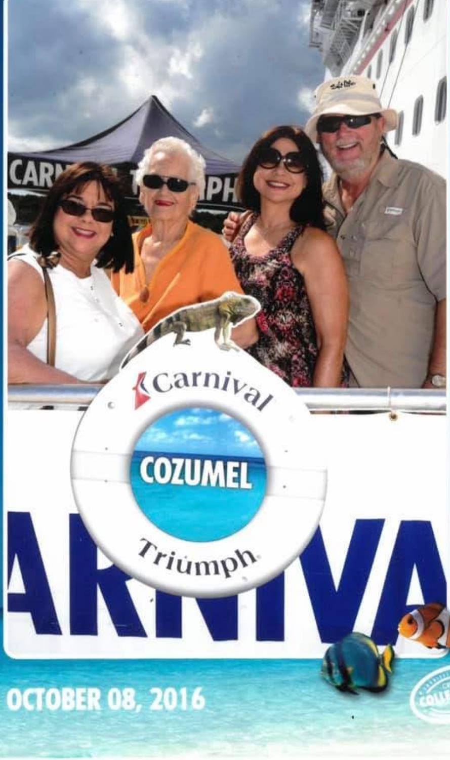 Four family members pose happily on the deck of a cruise ship in Cozumel, enjoying their vacation.