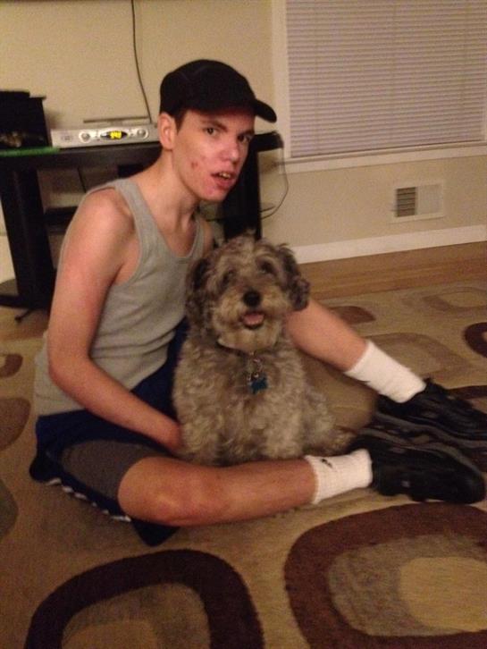 A young person enjoys the company of a furry dog in a warm and inviting living space.