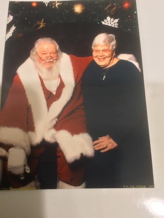 Santa Claus hugs a smiling person, sharing holiday cheer and warmth during the celebration.