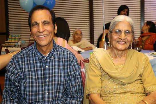 Two smiling people share a warm moment at a cozy family celebration.
