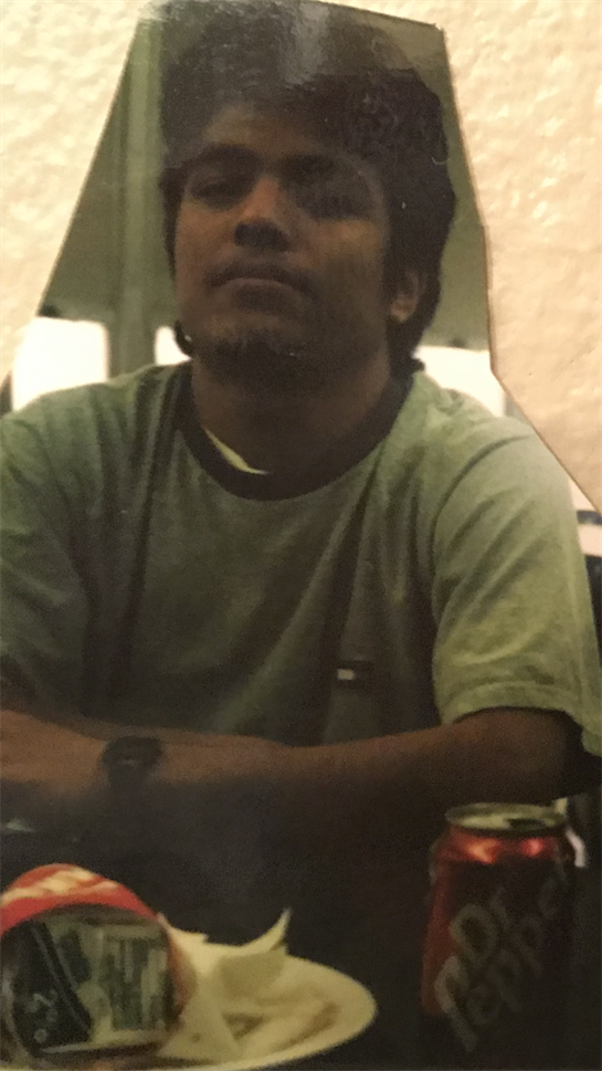 A man is seated at a table, deep in conversation during a relaxed indoor gathering.