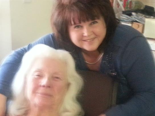 Two women enjoy a heartfelt moment together, radiating joy and connection in a cozy setting.