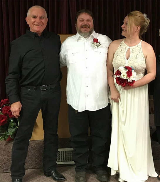 Two friends stand proudly beside the groom, sharing smiles during a heartfelt wedding.