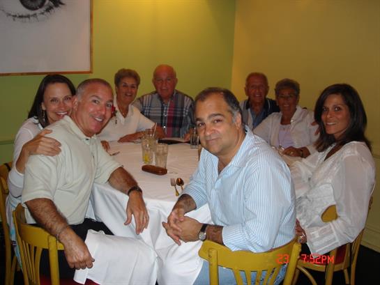 Group of friends enjoying dinner in a warm restaurant atmosphere while sharing smiles and stories.