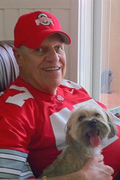 A friendly man enjoys time with his excited dog while watching a game on the couch.