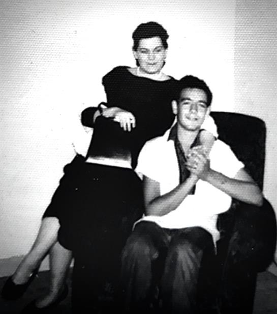 Two friends share a joyful moment in a retro living room, showcasing a timeless friendship.