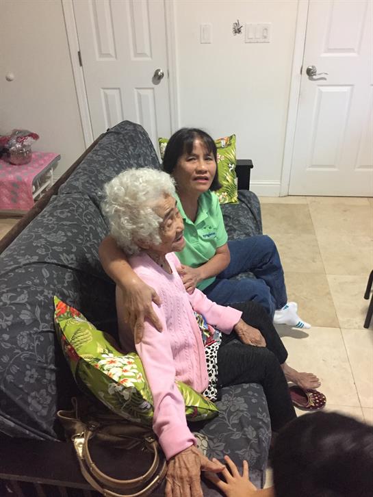 Two family members relax and share smiles on a sofa, surrounded by a warm and inviting living space.
