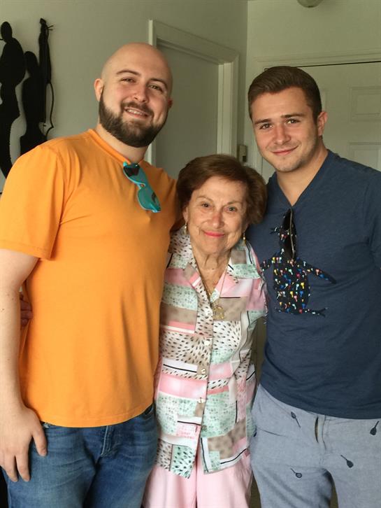 Two men and one woman pose happily together, enjoying a cozy moment indoors on a sunny day.