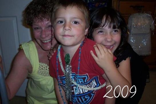 Joyful moment captured with children and an adult wearing colorful necklaces at a family event.