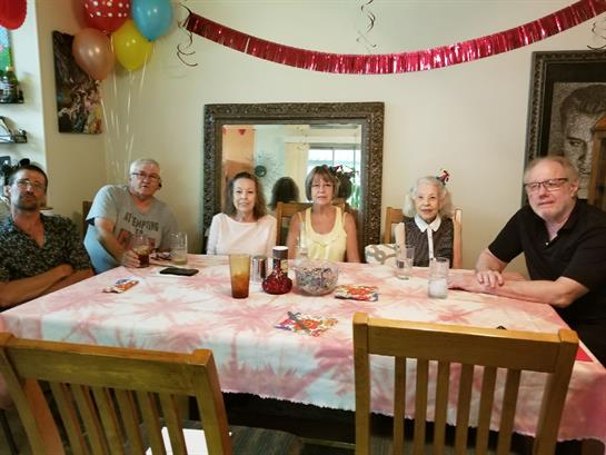Family members gather around a decorated table to celebrate a special occasion filled with joy.