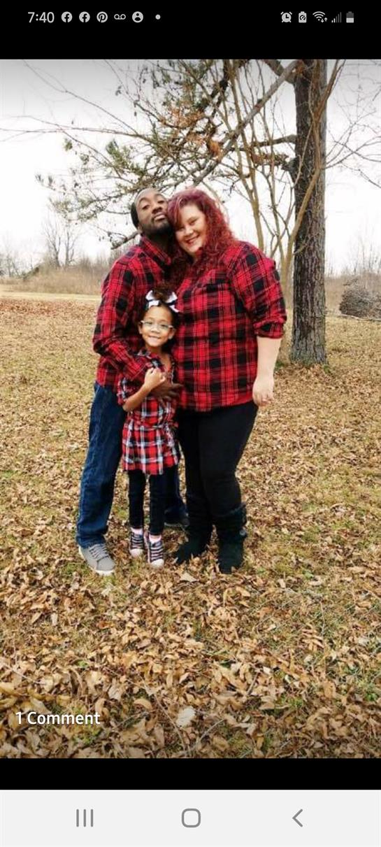 Family joyfully poses in a park with leaves, dressed in matching outfits, showing love.