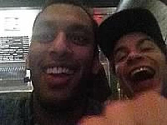 Two friends share smiles and laughter during a night out at a bustling urban venue.