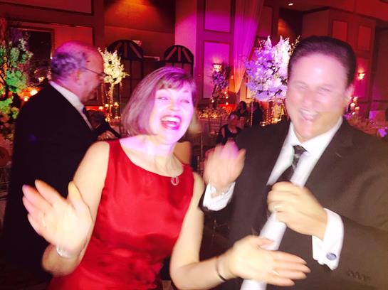 Couples dance and enjoy a festive atmosphere in a beautifully decorated venue.