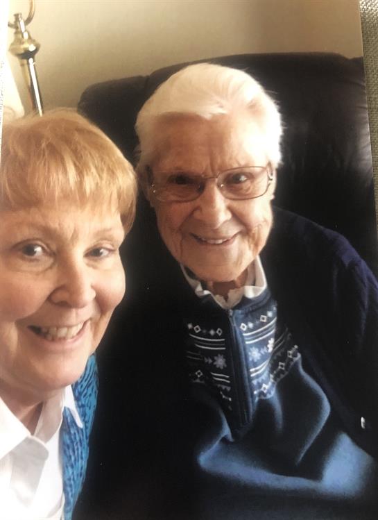 Two happy seniors pose for a selfie, sharing joy and warmth during their time indoors.