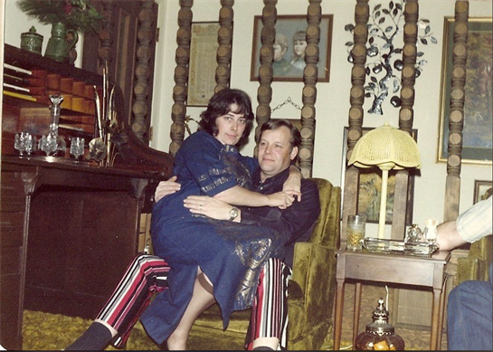 A couple shares an intimate moment in a retro living room filled with nostalgic decor.