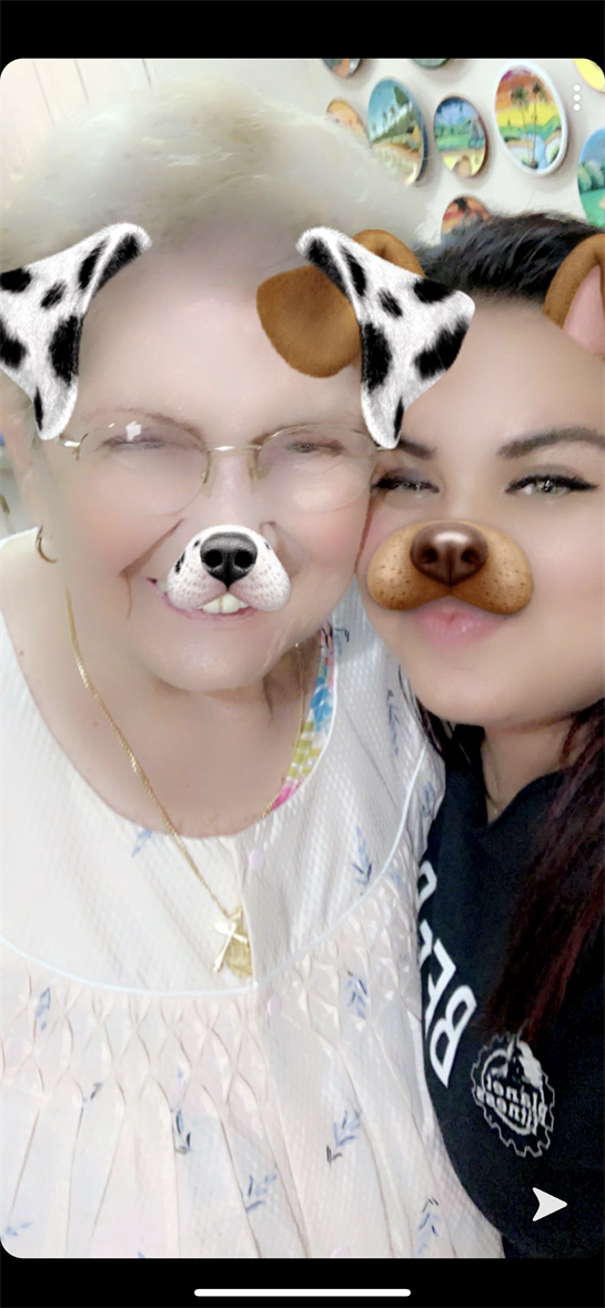 Two women pose joyfully with digital dog filters, showcasing their bond and happiness together.