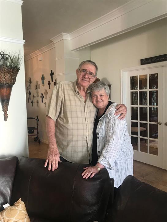 Seniors comfortably pose together in their cozy living room, enjoying each other's company.