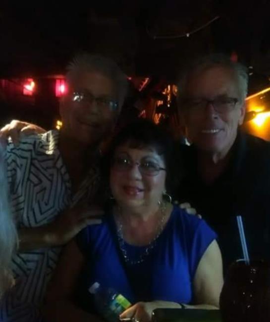 Group of friends enjoying a joyful night out, sharing laughter and drinks in a bar atmosphere.