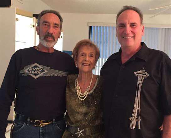 Three family members share joyful moments together, showcasing love and connection indoors.
