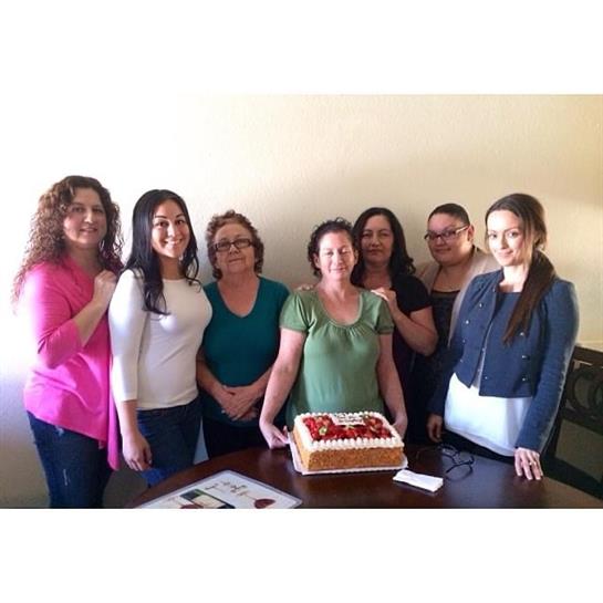Group of friends celebrate with a cake during a gathering inside a warm and inviting space.